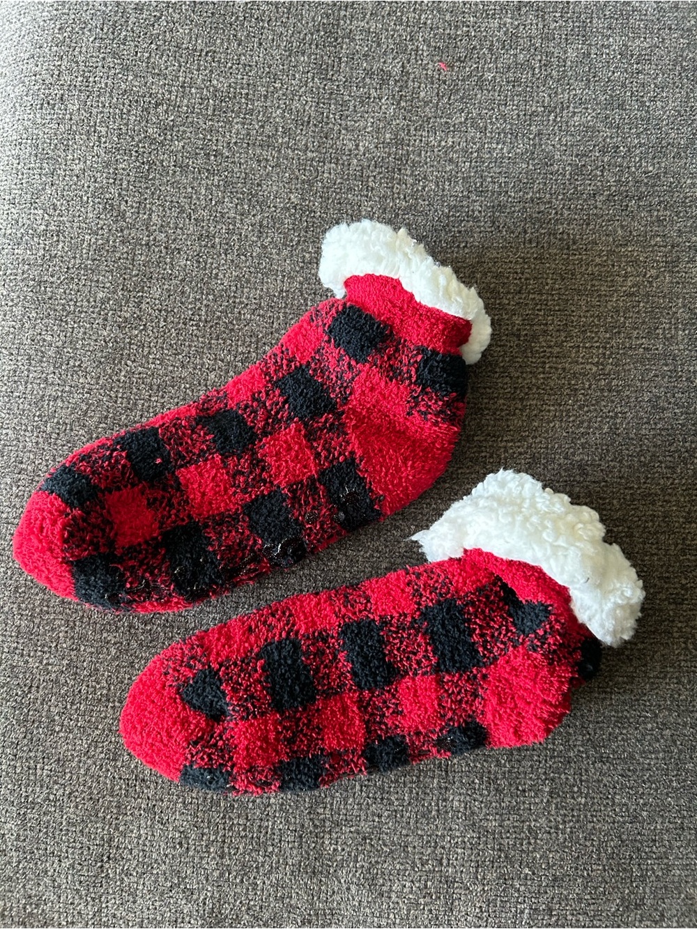 Red and black plaid thick socks with white fuzzy trim and grip bottoms